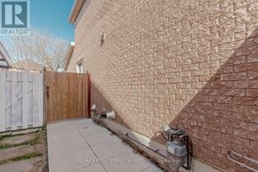 Mississauga (Central Erin Mills) apartment for rent - A brick wall with a white fence and a small garden in front.