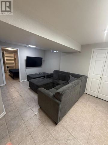 Toronto (West Humber-Clairville) apartment for rent - A living room with a grey couch and a flat screen TV mounted on the wall.