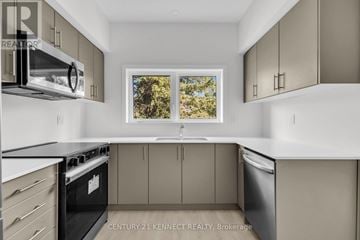 Guelph (Clairfields/Hanlon Business Park) townhouse for rent - A kitchen with white cabinets and a black stove top oven.