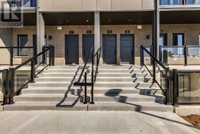 Guelph (Clairfields/Hanlon Business Park) townhouse for rent - Steps leading to a building entrance with the number 23 on the door.