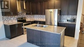 Clarington (Bowmanville) apartment for rent - A kitchen with a granite countertop and a refrigerator.