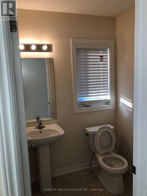 Clarington (Bowmanville) apartment for rent - A bathroom with a toilet, sink, and window.