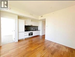 Vancouver apartment for rent - A spacious room with wooden flooring and a television.