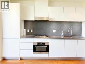 Vancouver apartment for rent - A modern kitchen with white cabinets and a stainless steel oven.