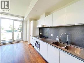 Vancouver apartment for rent - A modern kitchen with white cabinets and a wooden floor.
