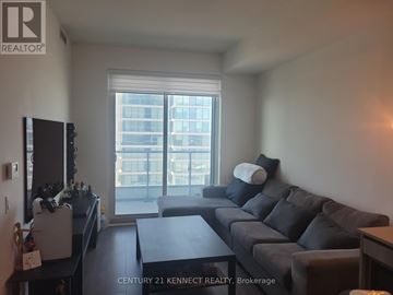 Vaughan (Vaughan Corporate Centre) condo for rent - A living room with a grey couch and a large window.