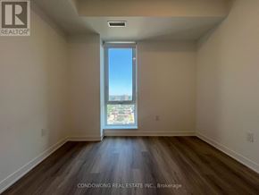 Toronto (Regent Park) condo for rent - Empty room with a large window overlooking a cityscape.