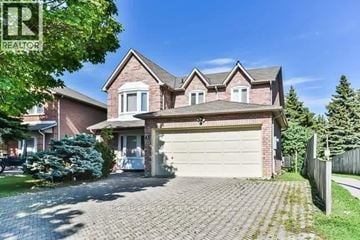 Markham (Middlefield) apartment for rent - A large house with a garage is surrounded by a fence and has a driveway.