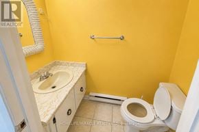 Mississauga (Meadowvale) townhouse for rent - A bathroom with yellow walls has a toilet, sink, and towel bar.