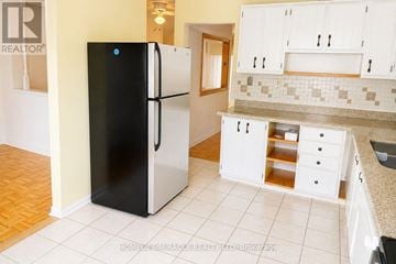Mississauga (Meadowvale) townhouse for rent - A black refrigerator in a kitchen with white cabinets.