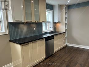 Toronto (Danforth Village-East York) apartment for rent - A kitchen with white cabinets and a black countertop.