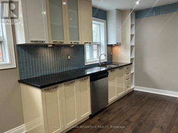 Toronto (Danforth Village-East York) apartment for rent - A kitchen with white cabinets and a black countertop.
