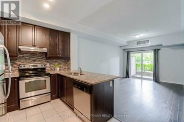 Mississauga (Mississauga Valleys) condo for rent - A kitchen with brown cabinets and a stainless steel oven.