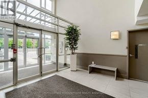 Mississauga (Mississauga Valleys) condo for rent - A lobby with a bench and a tree in a planter.
