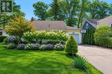 Oakville (Fd Ford) apartment for rent - A well-maintained lawn with a variety of flowers and shrubs in front of a house.