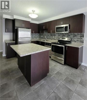 Kitchener townhouse for rent - A kitchen with brown cabinets and a marble island.
