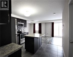 Kitchener townhouse for rent - A kitchen with black cabinets and a granite countertop.