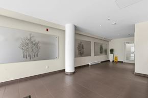 Surrey apartment for rent - A hallway with a white wall and a framed black and white tree picture.
