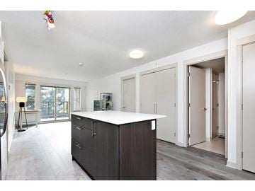 Surrey apartment for rent - A kitchen with a white counter top and dark wood cabinets.