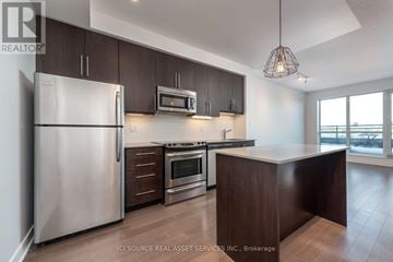 Toronto (Little Portugal) condo for rent - A modern kitchen with dark brown cabinets and stainless steel appliances.
