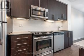 Toronto (Little Portugal) condo for rent - A modern kitchen with dark brown cabinets and stainless steel appliances.