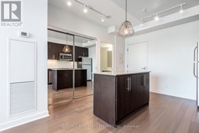 Toronto (Little Portugal) condo for rent - A modern kitchen with dark wood cabinets and a white interior.