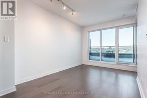 Toronto (Little Portugal) condo for rent - A room with a large window and wooden flooring.