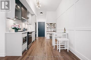 Oakville (Go Glenorchy) condo for rent - A modern kitchen with white cabinets and a wooden floor.