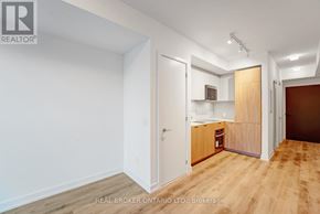 Toronto (Moss Park) condo for rent - A room with a white wall and a wooden floor.
