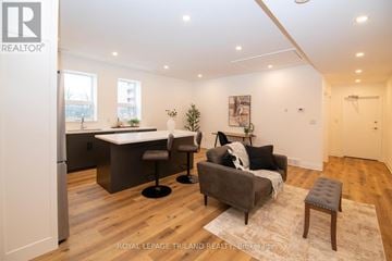 London East (East K) apartment for rent - A modern living room with a grey couch and a white dining table.