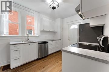 Welland apartment for rent - A kitchen with white cabinets and a grey counter top.
