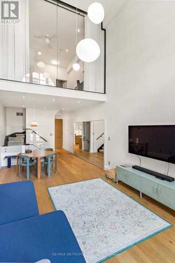 Toronto (Palmerston-Little Italy) condo for rent - A living room with a blue couch and a television.