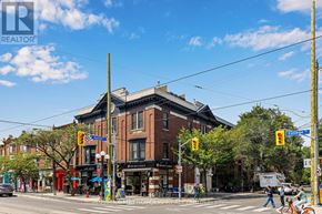 Toronto (Palmerston-Little Italy) condo for rent - A street view of a city intersection with traffic lights and pedestrians.