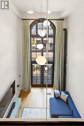 Toronto (Palmerston-Little Italy) condo for rent - A living room with a blue couch and a large window.
