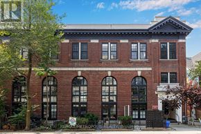 Toronto (Palmerston-Little Italy) condo for rent - A red brick building with a black fence in front.