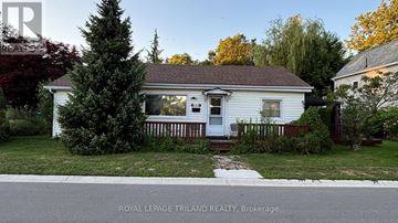 Central Elgin (Port Stanley) apartment for rent - A white house with a porch and a tree in front of it.
