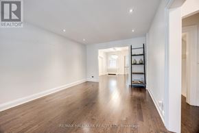 Toronto (Lawrence Park North) apartment for rent - A spacious room with wooden flooring and white walls.