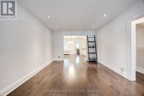 Toronto (Lawrence Park North) apartment for rent - A spacious room with wooden floors and white walls, featuring a ladder and a small table with chairs.