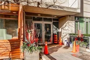 Toronto (Waterfront Communities) condo for rent - The entrance to a realtor's office is decorated with red and green plants.