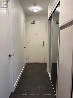 Toronto (Waterfront Communities) condo for rent - A hallway with a door on the left and a glass door on the right.