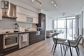 Toronto (Bay Street Corridor) condo for rent - A modern kitchen with a dining table and chairs.