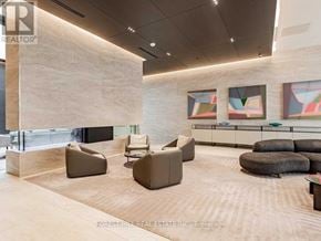 Toronto (Mount Pleasant West) condo for rent - A modern waiting room with a large stone wall and comfortable seating.