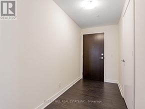 Toronto (Mount Pleasant West) condo for rent - A hallway with a door at the end and a brokerage logo on the wall.