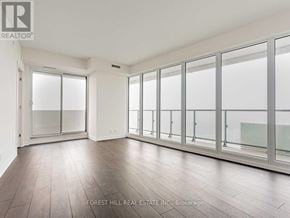 Toronto (Mount Pleasant West) condo for rent - A spacious room with wooden floors and large windows.