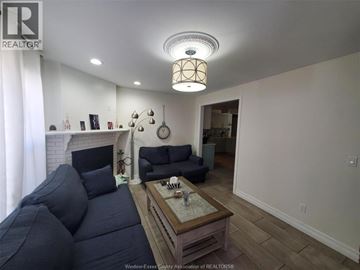 Windsor apartment for rent - A living room with a dark blue couch and a wooden coffee table.