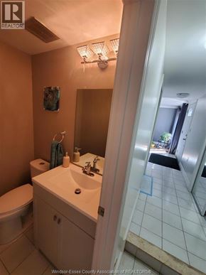 Windsor apartment for rent - A bathroom with a toilet, sink, and mirror.