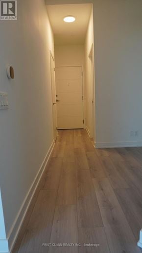 Toronto (Clairlea-Birchmount) condo for rent - A hallway with wood floors and white walls.