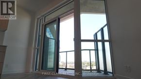 Toronto (Clairlea-Birchmount) condo for rent - A real estate company logo is displayed on a window in a room.