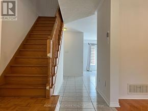 Richmond Hill (Langstaff) townhouse for rent - A wooden staircase leads up to a brightly lit landing.