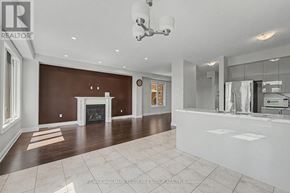 Barrie (Painswick South) apartment for rent - A large, empty living room with a fireplace and a kitchen area in the background.